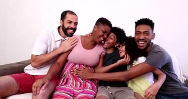 African family hugging in home sofa. Mixed race black parents and children embrace, love and affection
