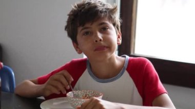 Preteen boy eating breakfast cereal in the morning breakfast