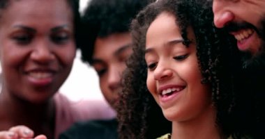 Komik mutlu aile cep telefonuna bakıp gülüyor.