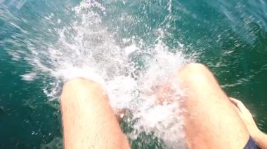 Man jumping into lake water in slow-motion. Person POV diving into lake