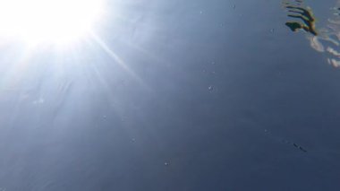 Sunlight flare under water. Clear crystal lake water sky sun rays