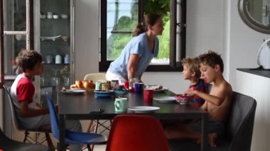 Aile sabah kahvaltı masasında. Çocuklar kahvaltı yapıyor.
