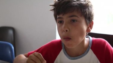Preteen boy eating breakfast cereal in the morning breakfast. Kid smiling at camera