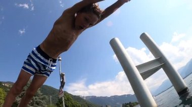 Child diving into lake water. Young boy dives into fresh natural water