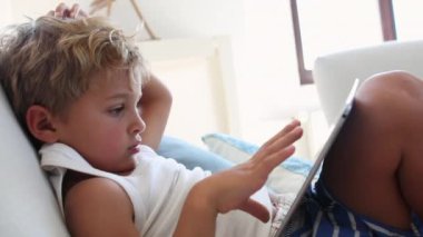 Child watching content online at home during quarantine. Kid staring at screen tablet