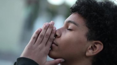 Religious young boy praying to GOD