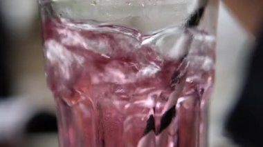 Glass cup with straw doing bubbles, close-up cup child doing bubbles