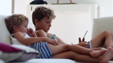 Candid children watching media entertainment on tablet. Kids looking at device screen