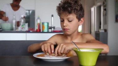 Child eating pancake in morning breakfast table