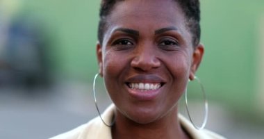 Confident black African woman smiling. Proud mixed race individual portrait face close-up