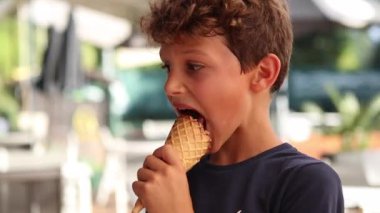 Child eating ice-cream. Young boy eats dessert chocolate ice cream