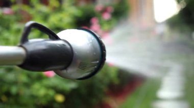 Close-up irrigation equipment watering garden backyard. Person spraying water
