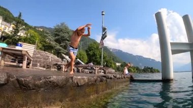 Young boy diving into lake water. Child dives into fresh water during summer vacations