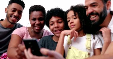 Family gathered together laughing and smiling over social media news