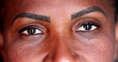 Afrikalı kadın kameraya gülümseyen gözler açıyor. Dişi gözler dik dik bakıyor