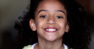 Karışık ırk küçük kız çocuğu kamera portresi yüzüne gülümsüyor.