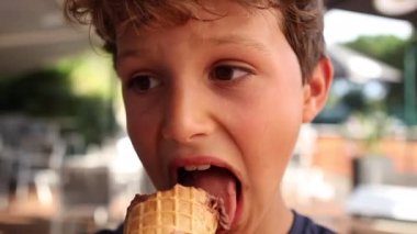 Child eating ice-cream. Young boy eats dessert chocolate ice cream