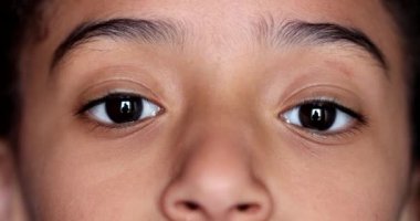 Küçük kız gözleri kameraya yakından bakıyor, makro yakın çekim.