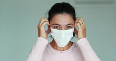 Girl putting on face mask prevention against Covid 19 pandemic. Woman wearing mask against corona virus infection