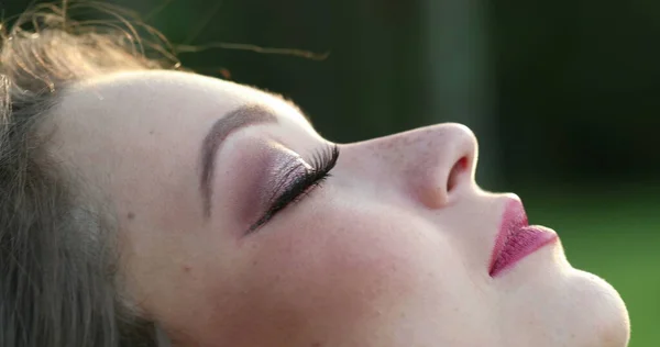 Young spiritual woman opening eyes looking to sky with hope and faith