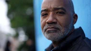 Kameraya yakından bakan ciddi bir siyah kıdemli adamın portresi.