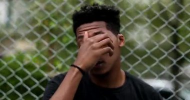 Portrait young black man looking at camera outside. Mixed race african male