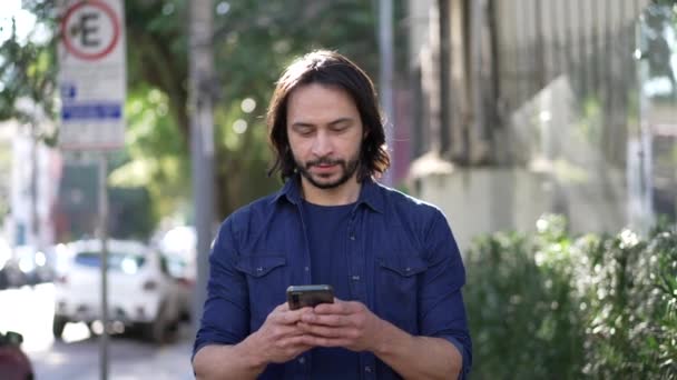 One Young Hispanic Man Looking Cellphone Device While Walking City — Stock videók
