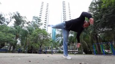 Urban dancer outside doing back flip. Hispanic man dancing