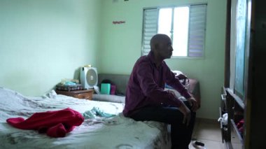 Düşünceli Afrikalı bir adam yatak odasında 50 'li yıllarda orta yaş günlerini düşünüyor.