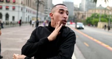 Hispanic man dancing in street outside performing to camera