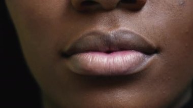 Siyahi bir kız ağzı kapalı, Afrikalı bir kadın makroyla karşı karşıya.