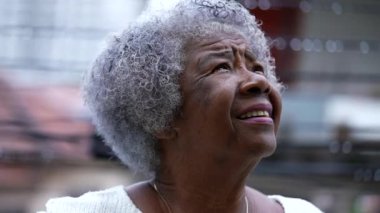 A Senior black woman looking up at sky face closeup