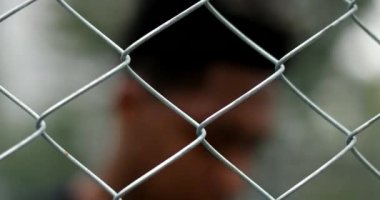 Young black african man seen through metal fence