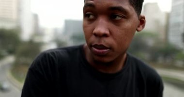 Frustrated young black African man standing outside in city