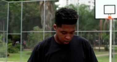African man feeling heat during warm day. person wiping sweat with t-shirt outside