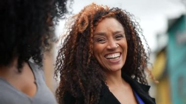 Mutlu bir siyahi kadın güler ve gülümser sıradan bir İspanyol 40 'lı yılların kadınına güler ve gülümser.