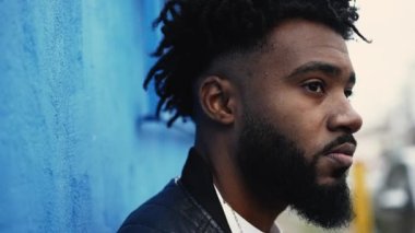 A pensive black man portrait face standing outside in street