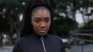 Genç bir Afrikalı kız kameraya bakıyor.