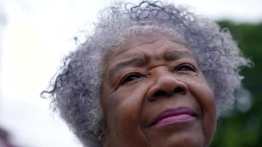 A senior black woman portrait looking up at sky face closeup