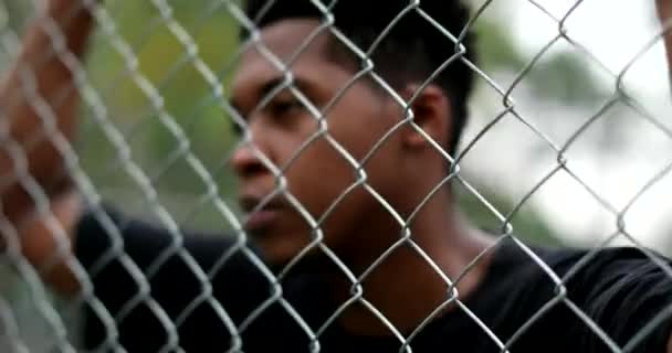 Thoughtful Young Black Man Leaning Metal Fence Basketball Court — Stock videók