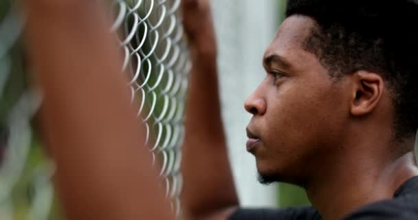 Contemplative Young Black Man Leaning Metal Fence — Vídeo de Stock