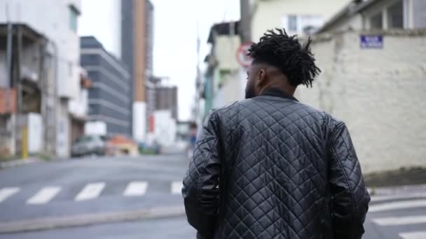 在城市里穿过街道的年轻黑人的后面 — 图库视频影像
