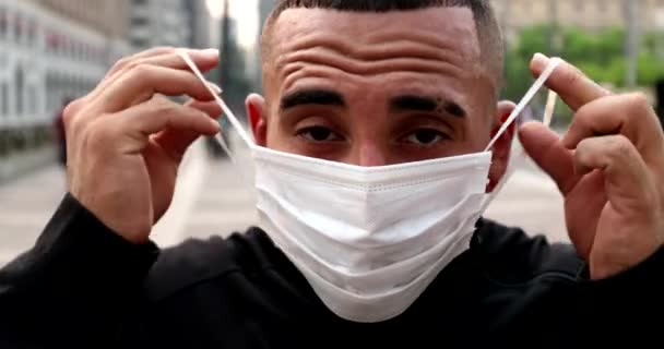 Hispanic Man Putting Surgical Face Mask City Background — ストック動画