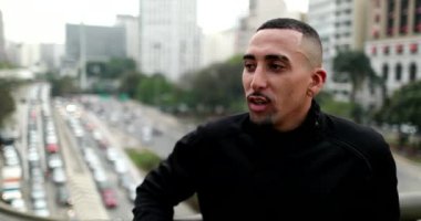 Casual Hispanic Brazilian young man in downtown city, real people