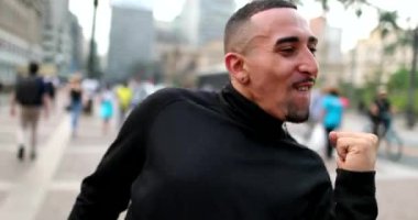Happy hispanic man receiving good news dancing in joy