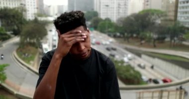 Stressed black African man standing in downtown city feeling anxiety