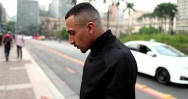 Hispanic man dancing looking at camera in downtown