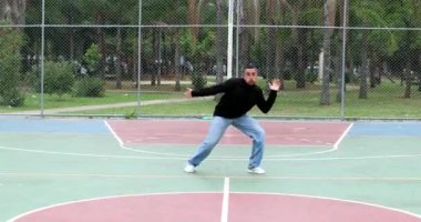Hispanic man performing urban dance outside