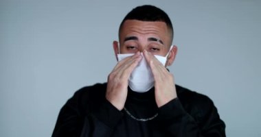 Hispanic man putting face mask on, prevention against pandemic