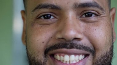 A smiling young black hispanic man close-up face looking at camera